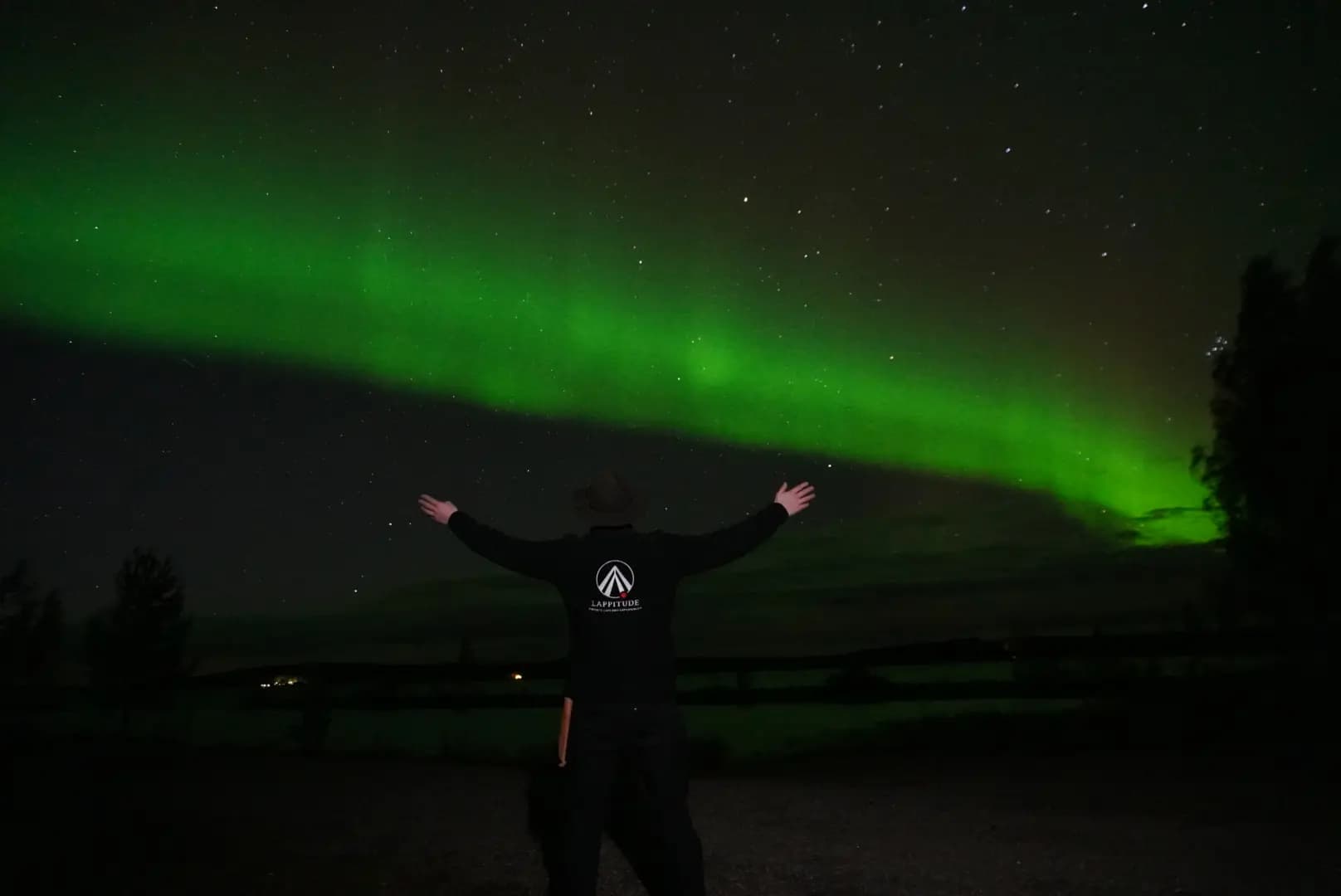 A guy standing in front of northern lights