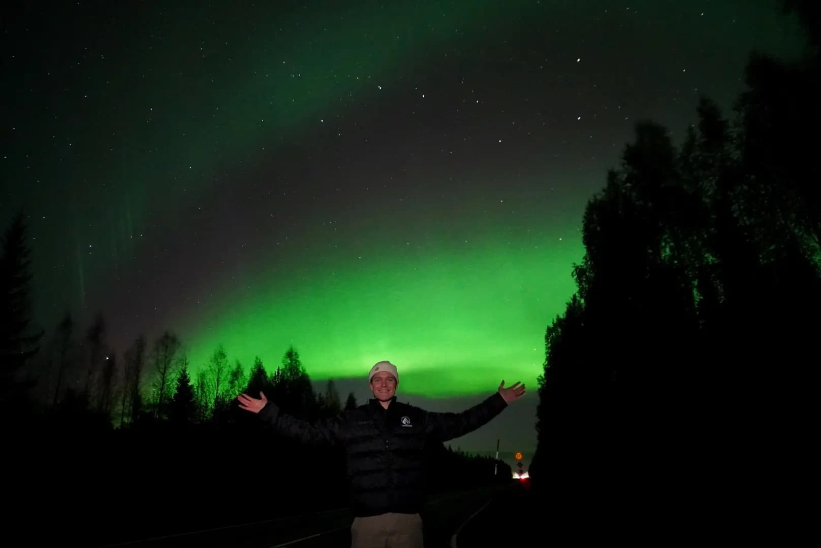 a guy with a jacket with lappitude logo in front of northern lights 2