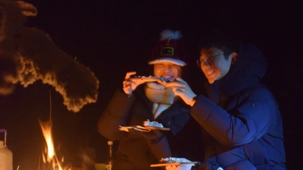 Customers enjoying snacks beside open fire